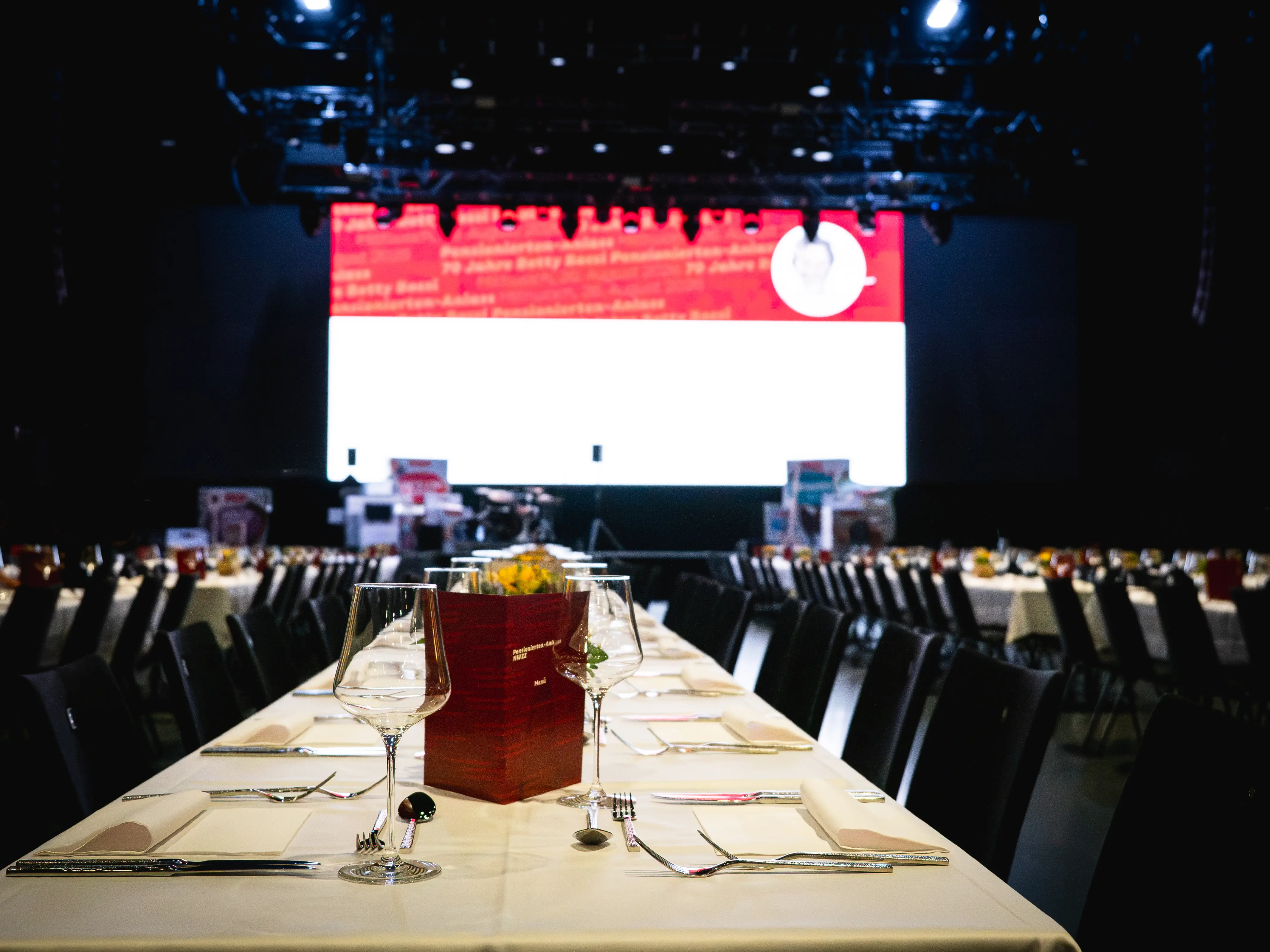 Gedeckte Tafel in der HALL mit Blick auf die Bühne beim Coop Pensionierten-Anlass